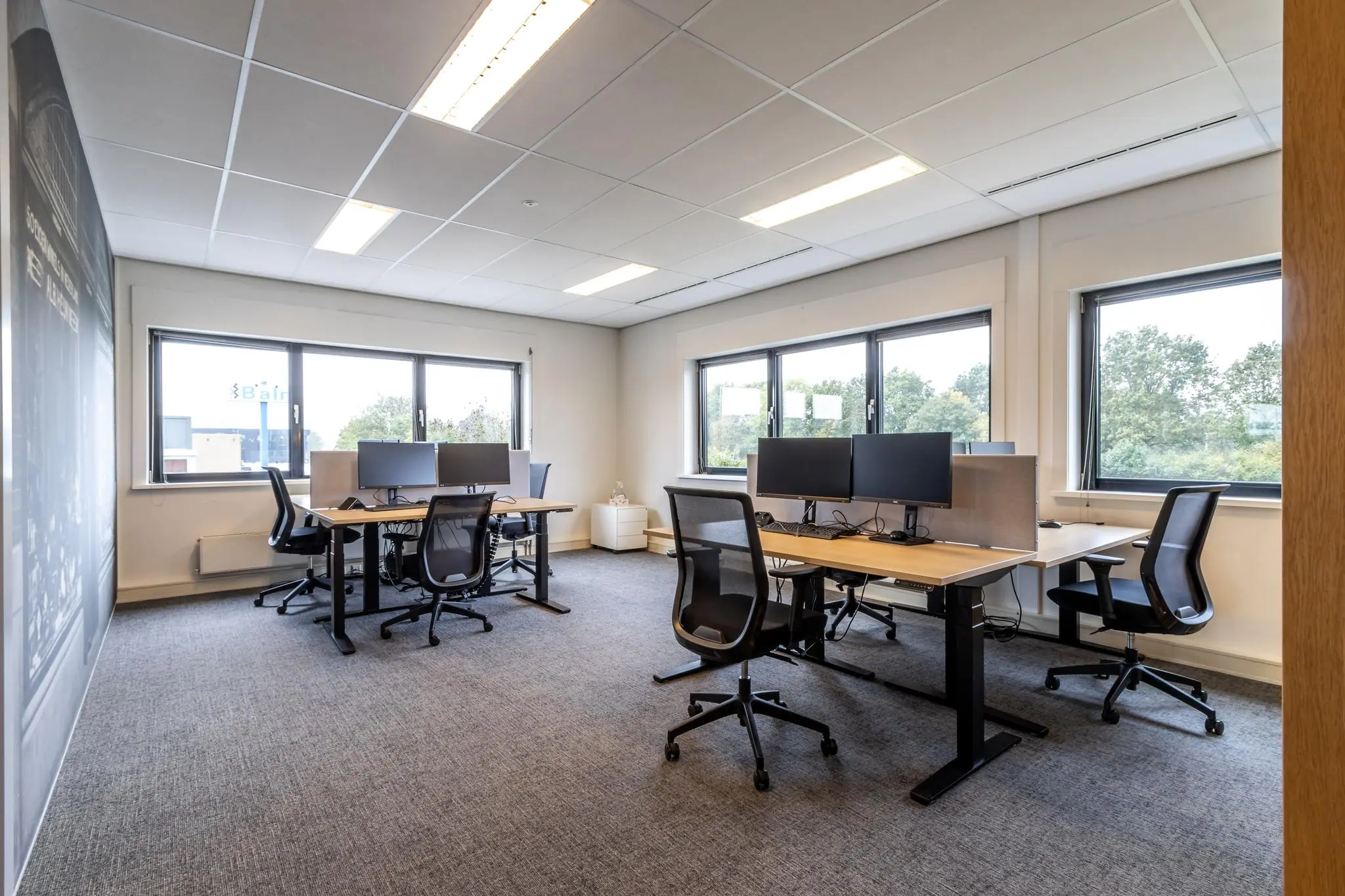 Moderne, lichte kantoorruimte aan de Lage Biezenweg met meerdere werkplekken en bureaustoelen.